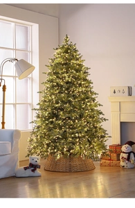 Close-up of a dense Christmas tree with warm LED lights and a brown woven tree skirt