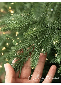 Detail of lush green pine needles and warm white LED copper wire lights for Christmas tree