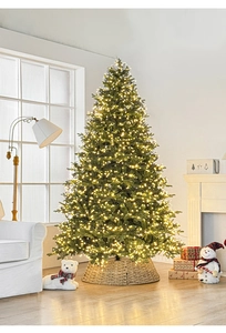 Detailed view of luxury pre-lit Christmas tree with warm LED lights and woven tree collar