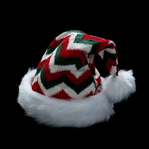 Classic knitted Christmas hat with wavy patterns and white plush trim on black background