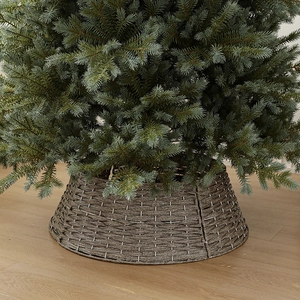 Lush green artificial Christmas tree with premium brown woven rattan tree collar base