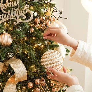 Luxuriöse weiße und goldene Glitzer-Weihnachtskugel, die an einem Tannenbaum hängt