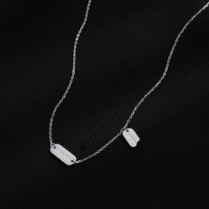 Detailed close-up of 925 sterling silver chain with Lucky engraved rectangular pendants