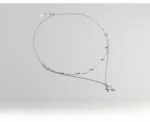 Detail of S925 sterling silver double-layer necklace with star pendant and silver beads