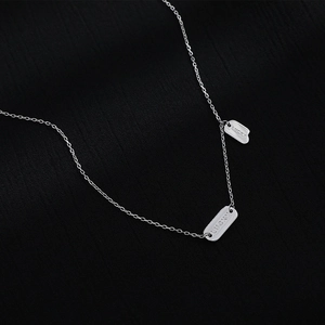 925 Sterling silver necklace with double lucky tags on black textured background
