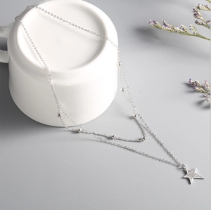 Double layer 925 silver necklace with beads and sparkling star pendant on white cup