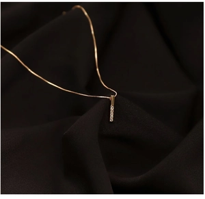 Dettaglio della collana con pendente a barra dorata in argento s925 e zirconi lucidi