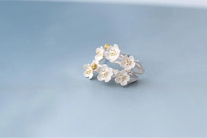 Detailed macro of 925 sterling silver ring with cherry blossoms and golden pistils