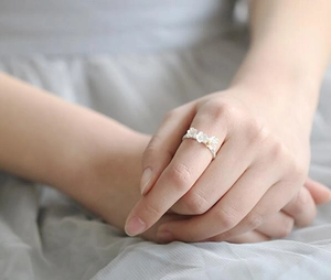 Detail of 925 sterling silver ring featuring three delicate cherry blossoms on finger