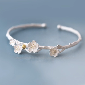 Macro shot of 925 silver plum blossom branch open bangle with golden pistils