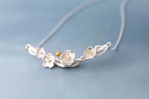 Macro shot of 925 sterling silver cherry blossom necklace with gold pistil details