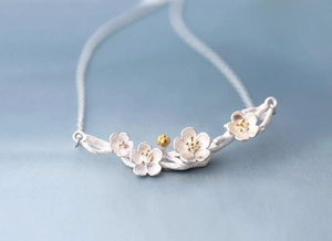 Macro detail of 925 sterling silver cherry blossom necklace with gold flower stamens