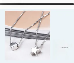 Close-up of polished S925 silver heart and star pendants on classic box chains