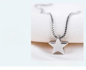 Macro detail of 3D silver star pendant with brushed finish and delicate box chain