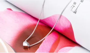 Detailed close-up of a 925 sterling silver heart pendant necklace on a floral background