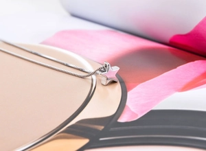 Detailed macro view of S925 sterling silver star pendant necklace on a modern background