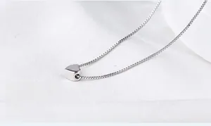 Macro shot of s925 silver heart pendant with 360-degree flat polishing on a white silk background