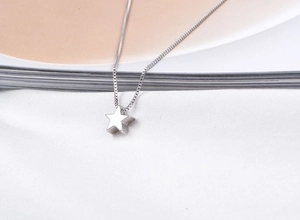 Macro shot of polished S925 sterling silver star pendant on box chain necklace