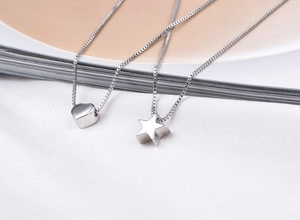 Detailed macro view of S925 sterling silver heart and star pendants on box chains