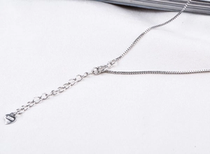 Macro detail of S925 sterling silver box chain with lobster clasp and heart tag