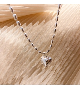 Detailed macro view of an S925 sterling silver heart pendant with beaded edge