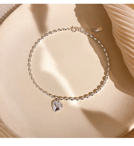 Macro detail of S925 sterling silver heart bracelet with oval beads and clasp