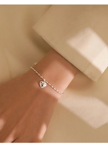 Close-up of S925 sterling silver rice bead bracelet with a vintage textured heart pendant