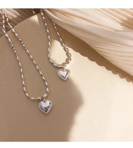 Macro view of S925 sterling silver heart necklaces with rice bead chains and beaded edge