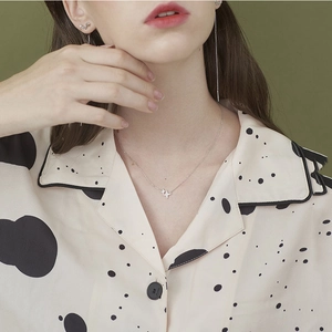 Silver four-pointed star necklace and earrings set worn on a model with a retro style