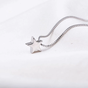 Minimalist S925 sterling silver necklace with a polished 3D star pendant on white silk