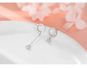 Detailed view of asymmetric S925 silver hoop earrings with clear cubic zirconia stones