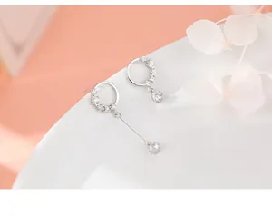 Detailed close-up of asymmetric S925 silver hoop earrings with sparkling zircon stones
