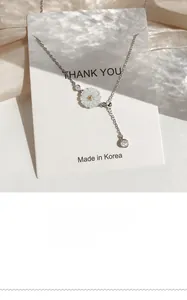 Detailed close-up of 925 silver daisy necklace with white shell petals and gold center