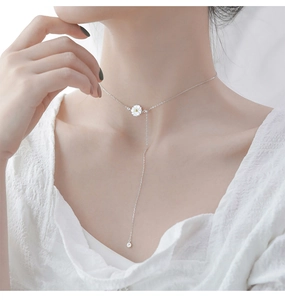 Detailed view of 925 silver daisy pendant with Y-shaped tassel necklace on model