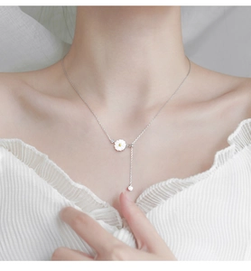 Close-up of 925 sterling silver necklace with white daisy flower pendant on model