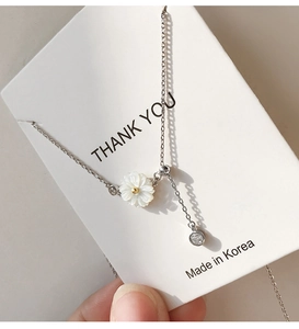 Detailed close-up of 925 sterling silver daisy necklace with shell petals and zircon