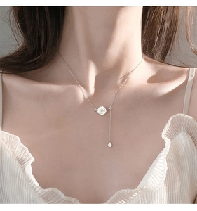 Detail of 925 silver daisy necklace with tassel zircon pendant on a model's neck