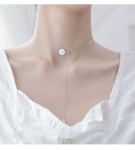 Close-up of 925 sterling silver daisy necklace with sparkling tassels on female model