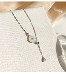 Detailed shot of 925 silver necklace with shell daisy pendant and zircon details