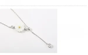Macro shot of 925 silver necklace with white daisy pendant and sparkling cubic zirconia