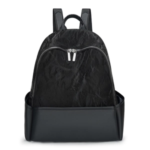 Minimalist black backpack with textured fabric and smooth matte leather panel contrast