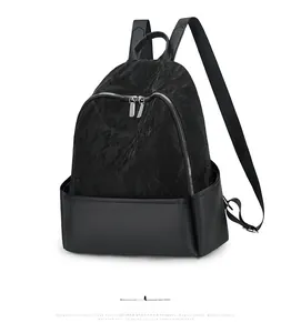 Detail view of the black nylon backpack showing leather patchwork and silver zippers