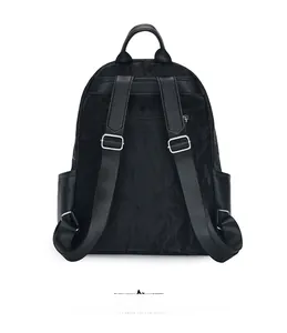 Detail view of black nylon backpack back panel with anti-theft pocket and wide straps