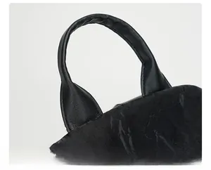 Detail of the reinforced top handle on a black leather backpack with visible stitching