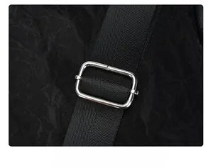Detail of adjustable black woven strap with a silver rectangular metal buckle on backpack