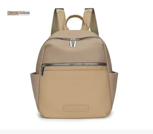 Detail of a brown waterproof oxford backpack showing smooth silver metal zippers and pockets