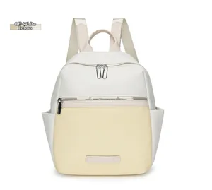 Detailed front view of a cream white oxford fabric backpack with silver dual zippers