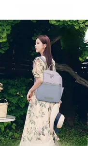 Outdoor shot of the lavender and blue nylon拼接 backpack with a front zipper pocket