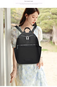 Minimalist black oxford backpack shown on a model in a purple floral dress for a casual look