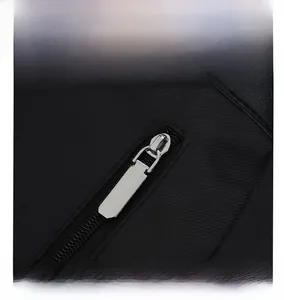 Close-up of sleek silver metal zippers on durable black oxford fabric backpack